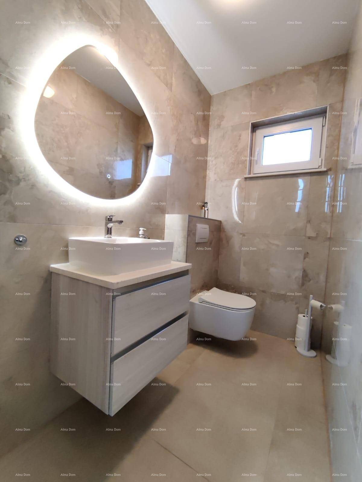 Modernes Badezimmer mit großformatigen Fliesen, beleuchtetem Spiegel und schwebendem Waschtisch.