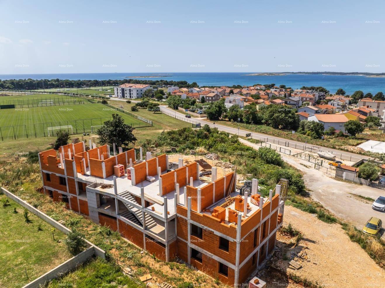 Luftaufnahme der Baustelle mit dem Rohbau des Gebäudes und der weiteren Umgebung.