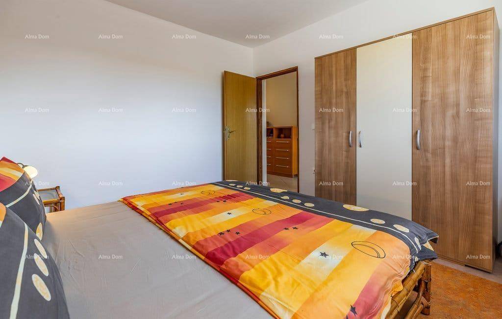 Schlafzimmer mit Doppelbett und großem Kleiderschrank in Holzoptik für ausreichend Stauraum.