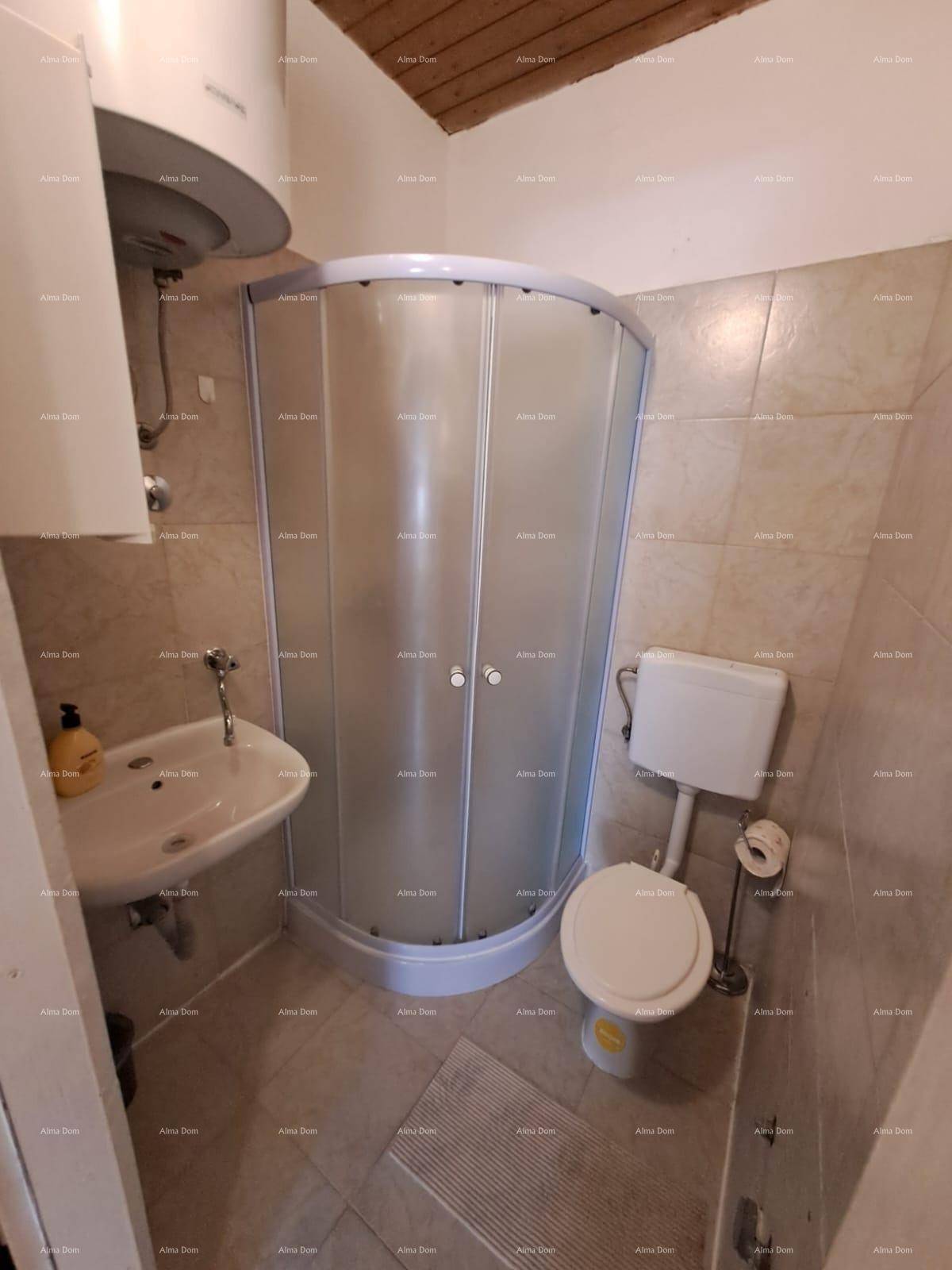 Kompaktes Badezimmer mit Eckduschkabine, Toilette und Waschbecken, vollständig gefliest.