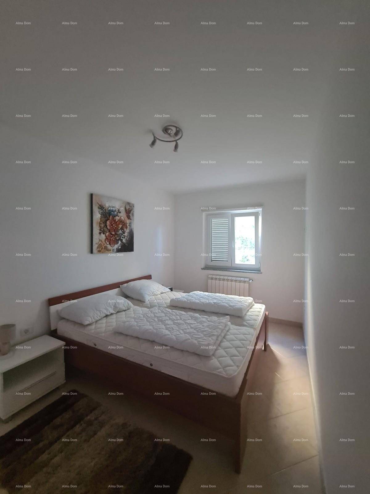 Schlafzimmer mit Doppelbett, Nachttisch und Fenster mit Jalousien, hell beleuchtet.
