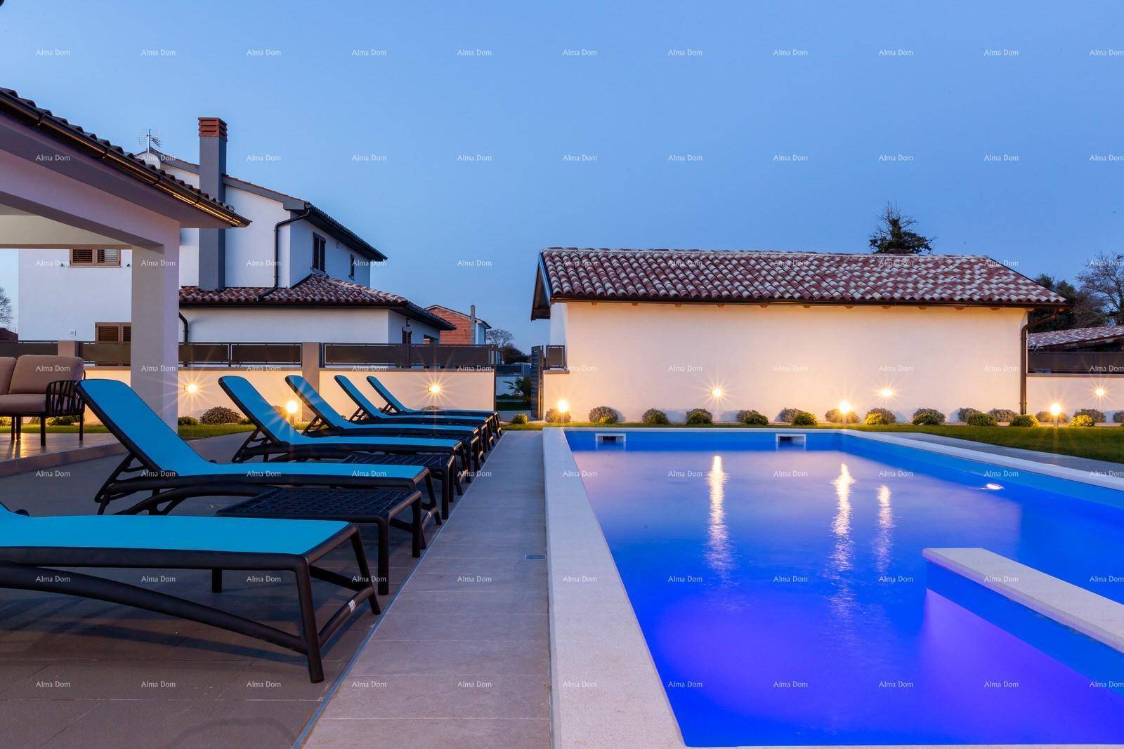Weitläufiger Poolbereich mit zahlreichen Liegestühlen und beleuchteter Gartenanlage am Abend.