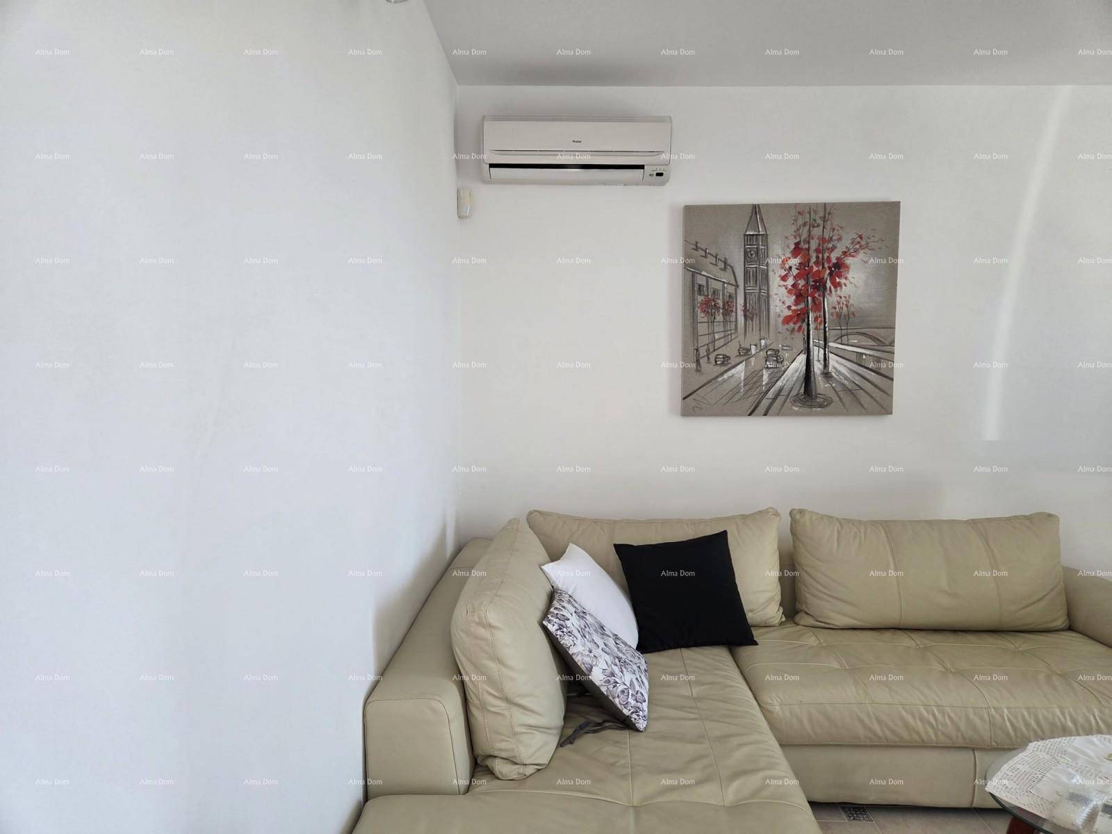Ecksofa in hellem Wohnzimmer mit Klimaanlage und Wandbild.