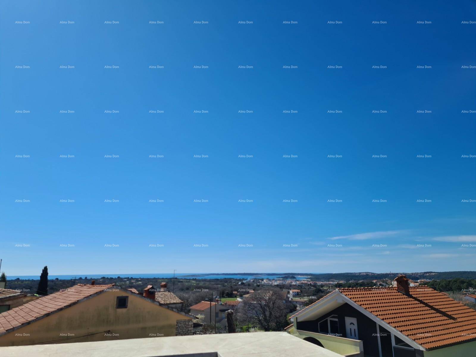 Panoramablick über die Küstenlandschaft mit Häusern und dem Meer in der Ferne.