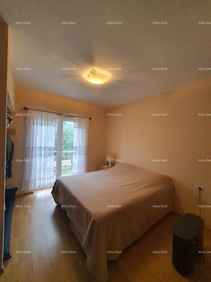 Schlafzimmer mit Doppelbett, Holzboden und Zugang zu einem Balkon oder einer Terrasse.