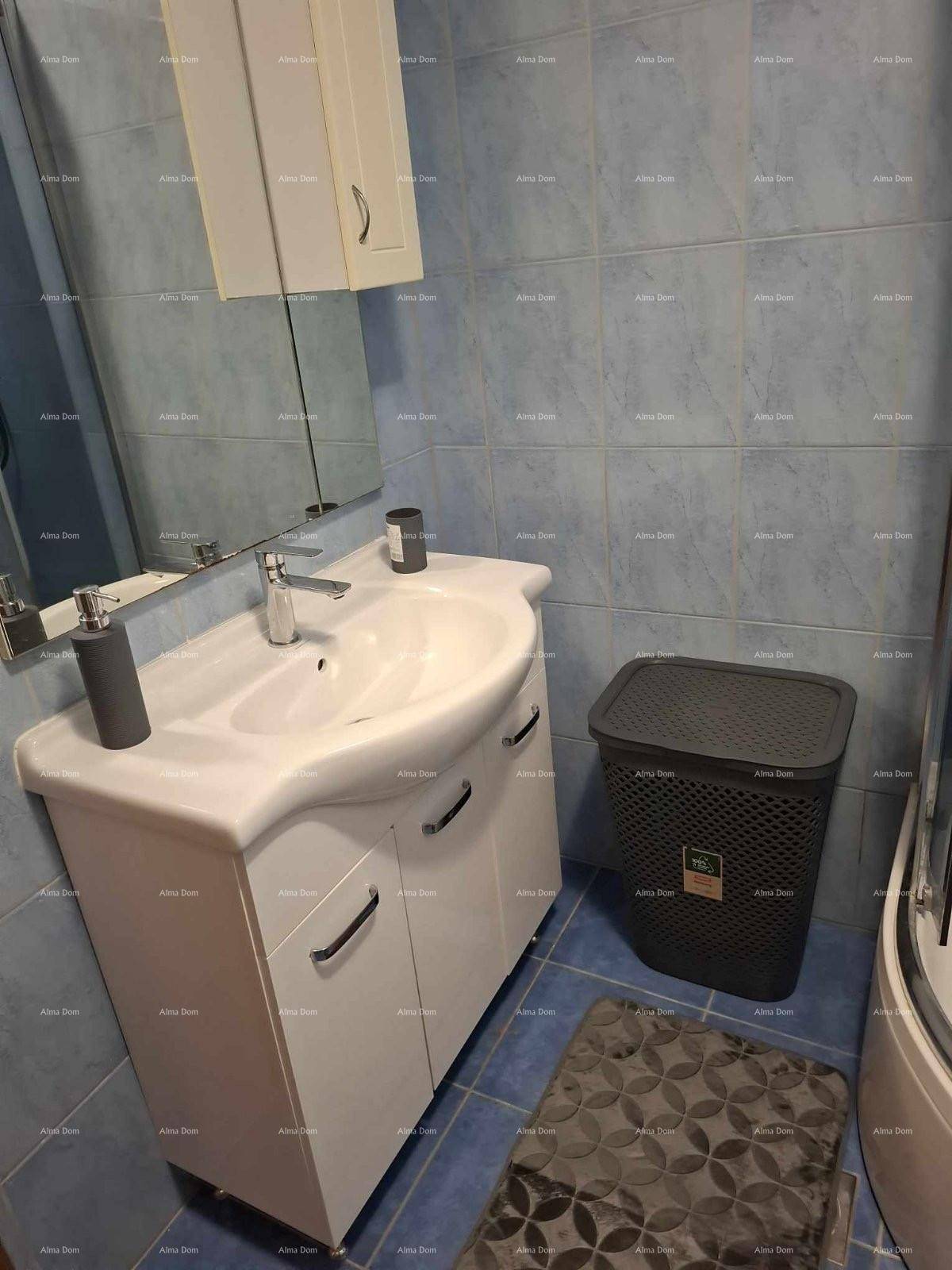 Badezimmer mit blau gefliesten Wänden, modernem Waschbecken und Spiegelschrank.