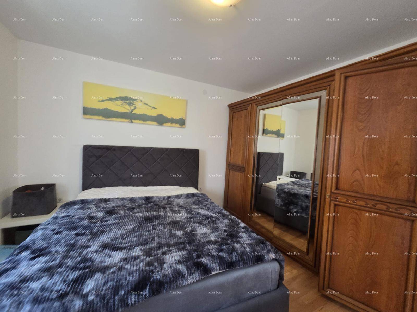 Schlafzimmer mit großem Doppelbett, Holzboden und einem Spiegelschrank.