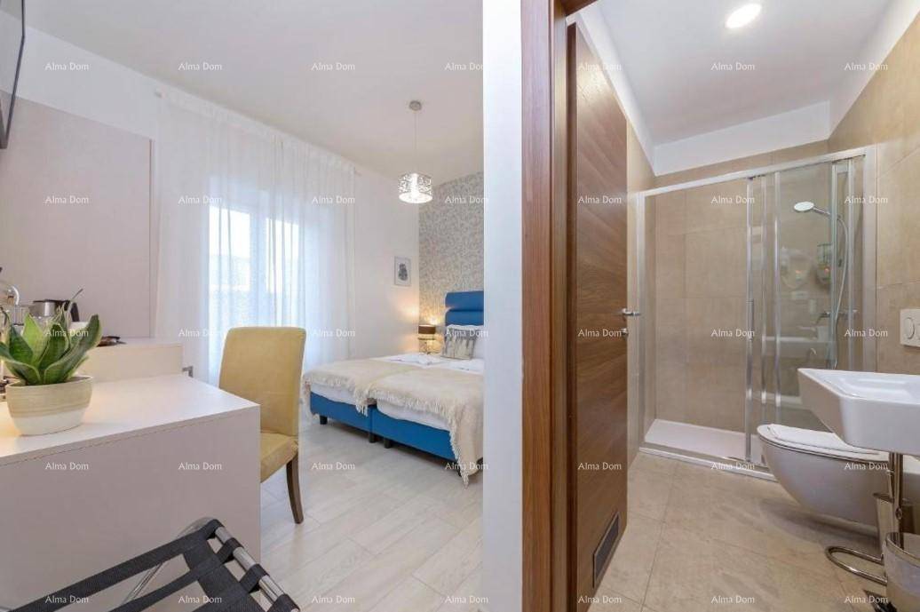 Helles Schlafzimmer mit Blick auf das angrenzende Badezimmer mit Duschkabine und WC.