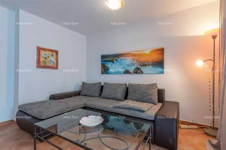 Gemütliches Wohnzimmer mit Ecksofa, Glastisch und dekorativen Bildern an den Wänden.