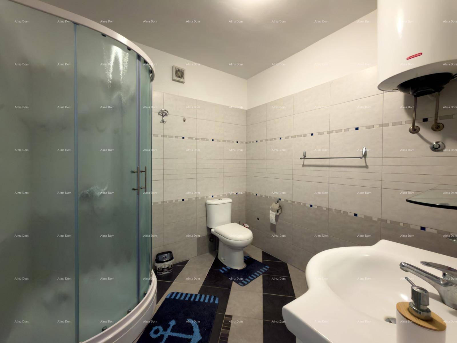 Modernes Badezimmer mit Duschkabine, WC, Waschbecken und hellen Fliesen an den Wänden.