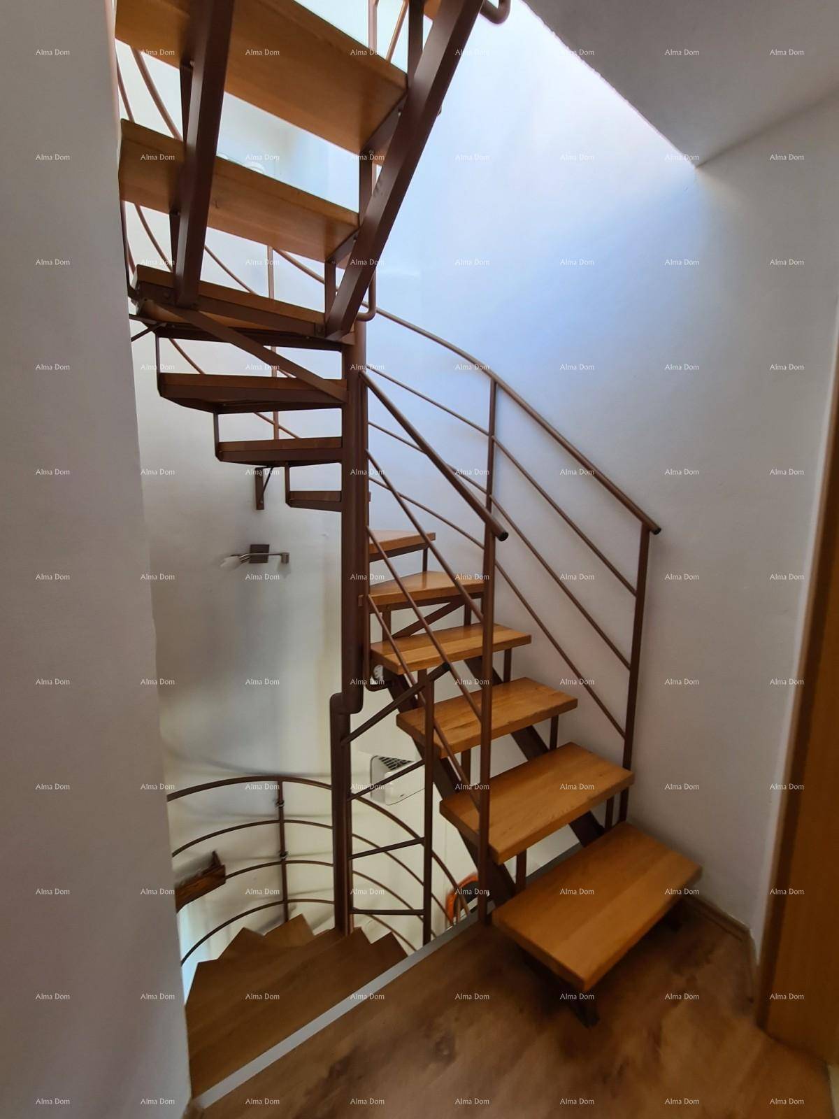 Helle Diele mit einer eleganten Holz-Metall-Wendeltreppe, die verschiedene Ebenen des Hauses verbindet.