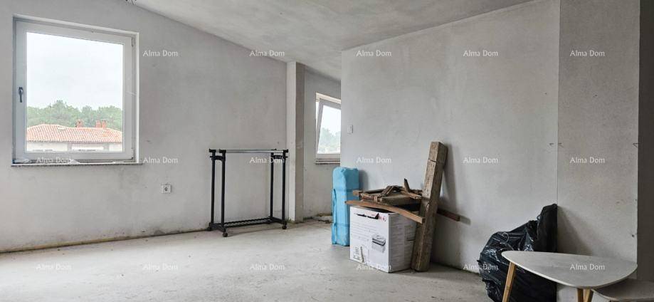 Heller, unfertiger Raum mit zwei Fenstern und Betonboden, der auf den Innenausbau wartet.