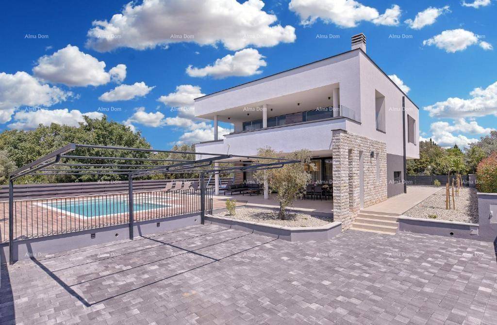 Moderne Villa mit gepflasterter Auffahrt und Poolbereich im Hintergrund unter blauem Himmel.
