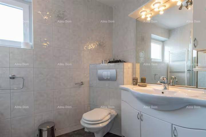 Modernes Badezimmer mit Toilette, Waschbecken, großem Spiegel und Fenster.