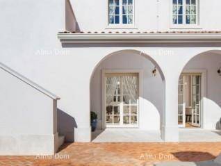 Elegante weiße Fassade des Gebäudes mit dekorativen Bögen und großen Fenstern im Erdgeschoss.