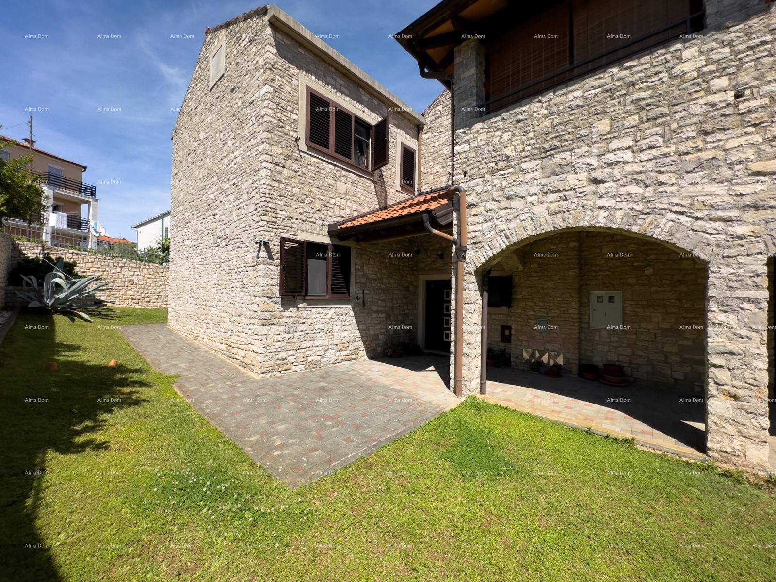 Steinhaus mit gepflegtem Rasen und einem überdachten Bereich im Erdgeschoss.