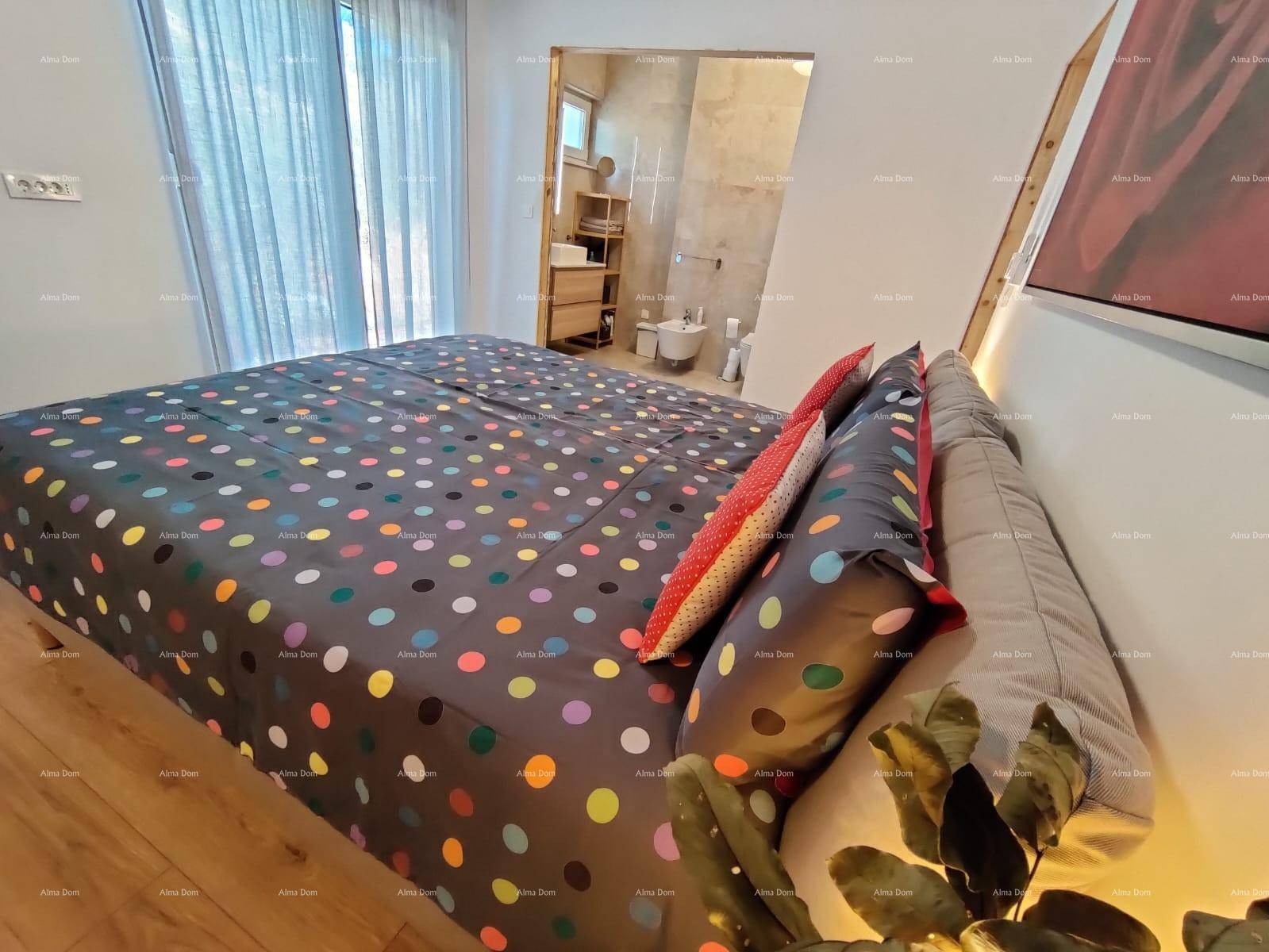 Schlafzimmer mit Holzboden, großem Bett und Blick auf das angrenzende Badezimmer.