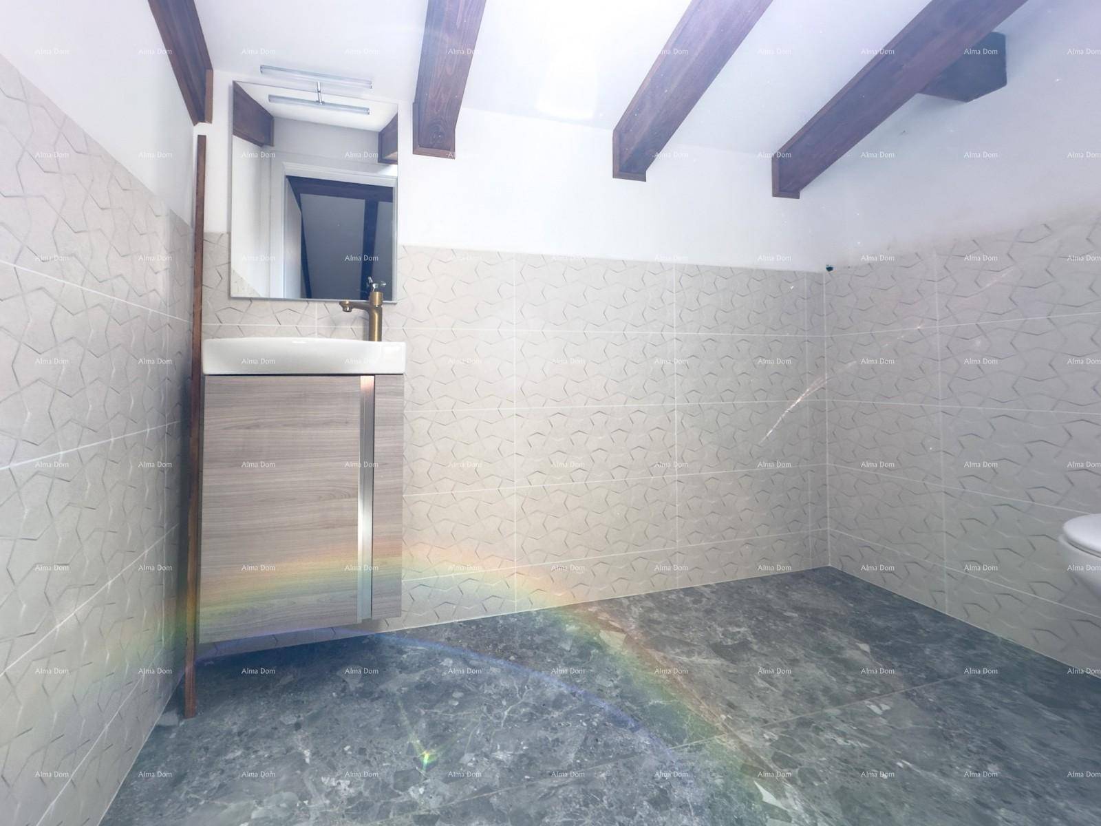 Modernes Badezimmer mit Waschtisch, Wand-WC, Holzbalken und einem Dachfenster für natürliches Licht.
