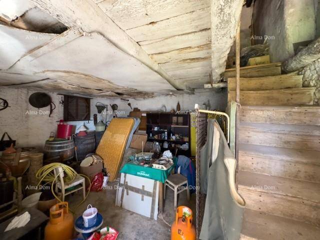 Unaufgeräumter Kellerraum mit Holztreppe, freiliegenden Balken und verschiedenen Lagergegenständen.