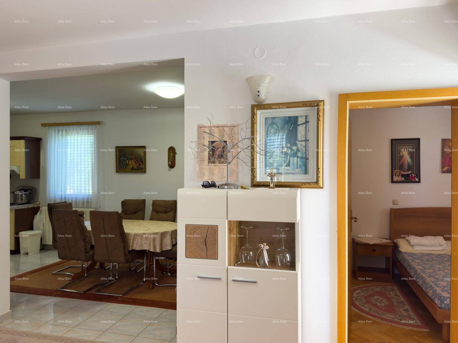 Essbereich mit großem Esstisch und Stühlen, angrenzend an die Küche und ein Schlafzimmer.