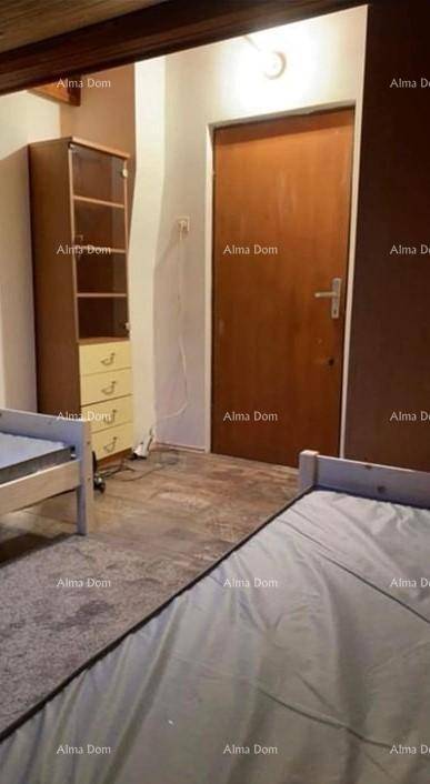 Schlafzimmer mit zwei Betten, einem Holzschrank und einer Holztür.