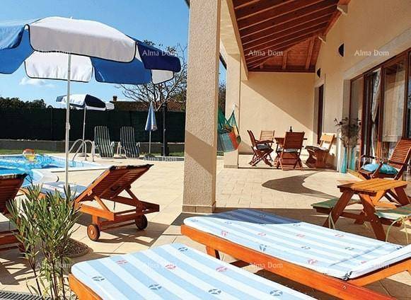 Weitläufiger Poolbereich mit zahlreichen Sonnenliegen, Sonnenschirmen und einer überdachten Terrasse.