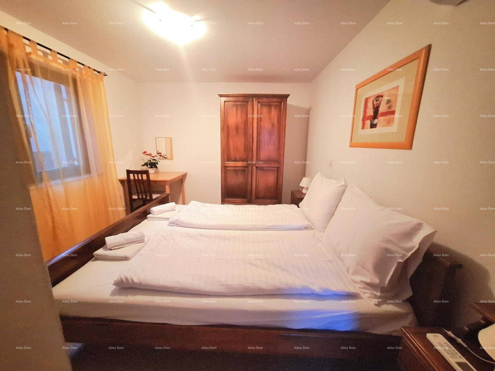 Gemütliches Schlafzimmer mit Doppelbett, Holzschrank und Fenster mit Vorhängen.