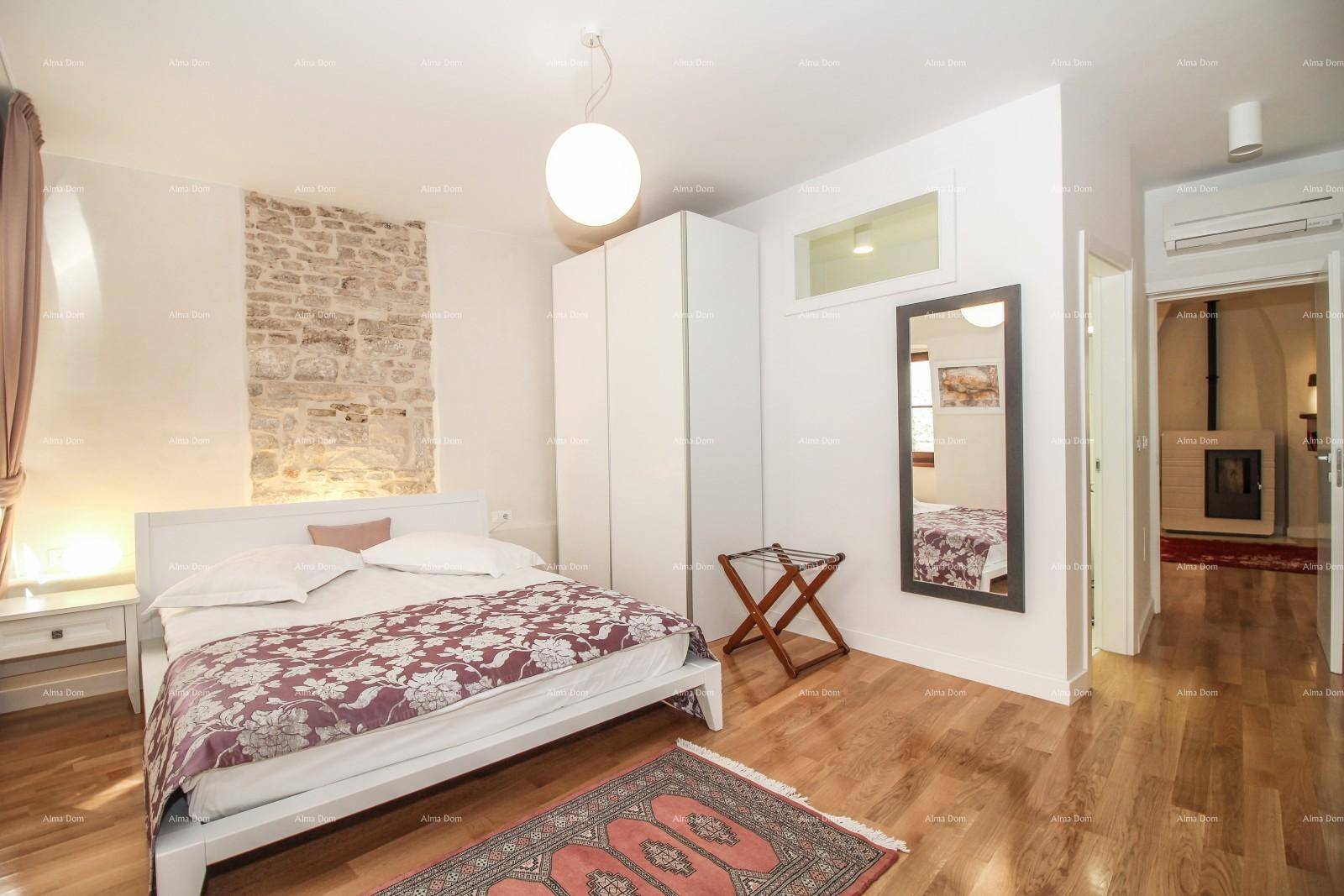 Schlafzimmer mit Doppelbett, weißen Kleiderschränken und Holzboden, hell und modern eingerichtet.