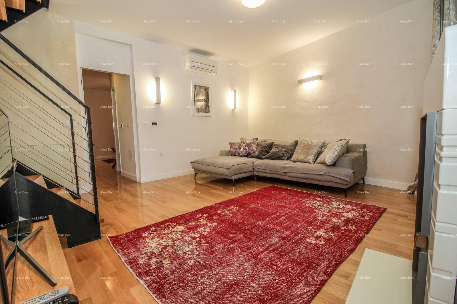 Wohnzimmer mit Holzboden, rotem Teppich und einer modernen Couch, die zum Entspannen einlädt.