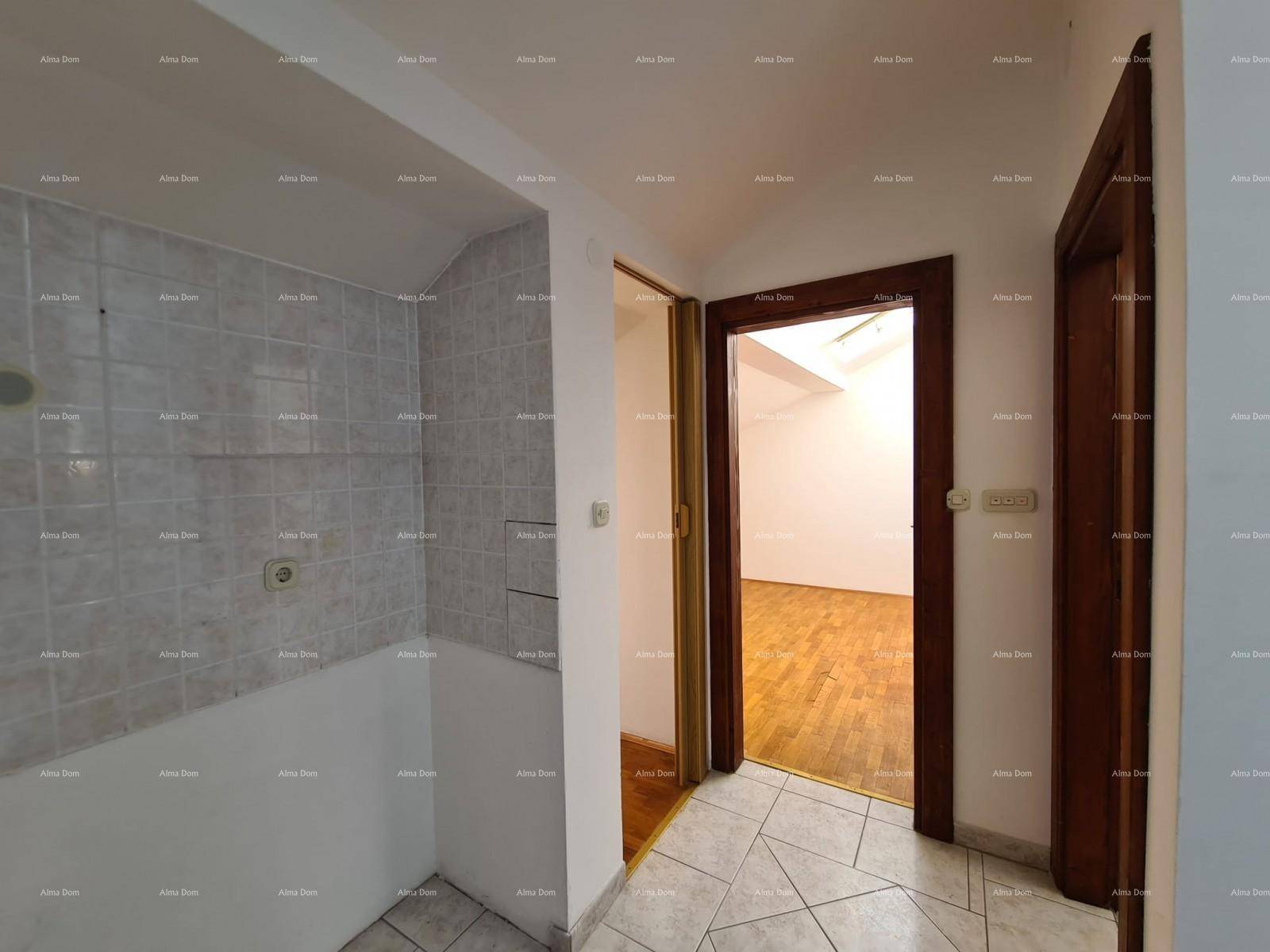 Flur mit Zugang zu einem unfertigen Küchenbereich und einem Zimmer mit Holzparkettboden.