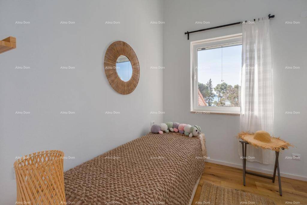 Kleines Schlafzimmer mit Einzelbett, Holzboden und einem Fenster für natürliches Licht.