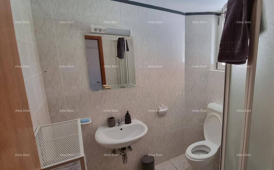 Badezimmer mit Fliesen, Waschbecken, Toilette und Duschbereich.