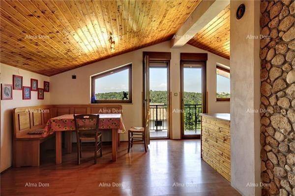 Gemütlicher Wohn-Essbereich mit Holzbalkendecke, Holzboden und Zugang zum Balkon.