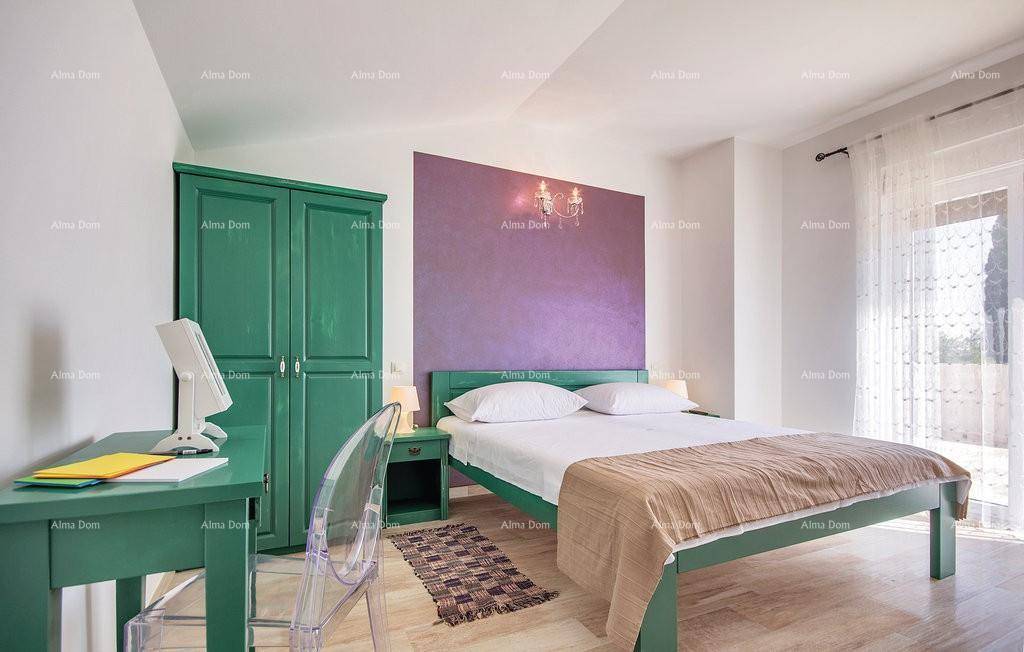 Schlafzimmer mit Schreibtisch, grünen Möbeln und Fenster für Tageslicht.