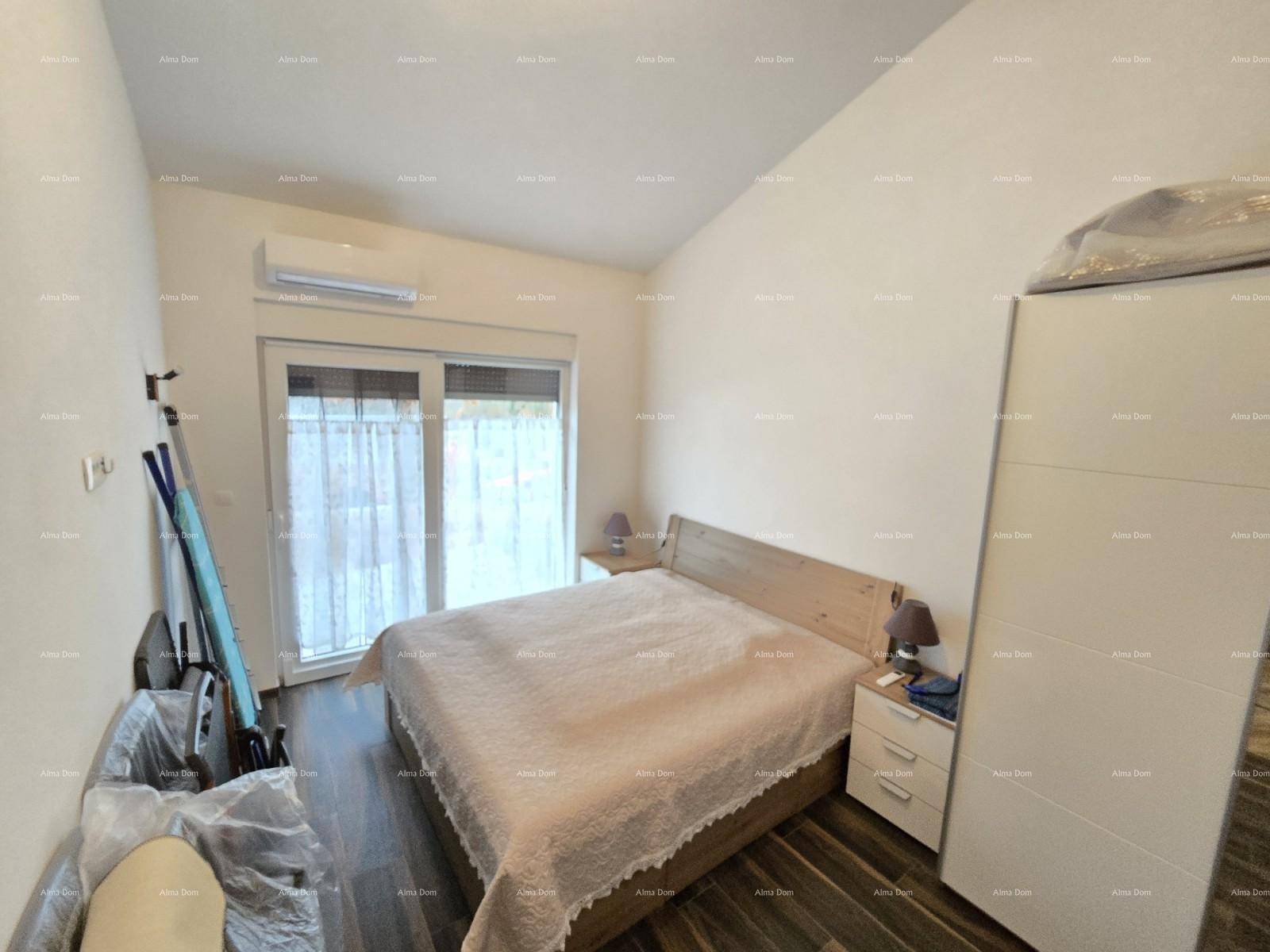 Schlafzimmer mit Doppelbett, Kleiderschrank und Zugang zur Terrasse.