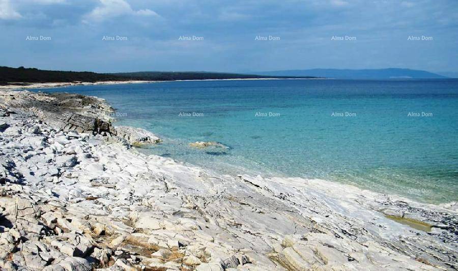 Malerische Felsküste mit klarem, türkisfarbenem Meer unter einem blauen Himmel.