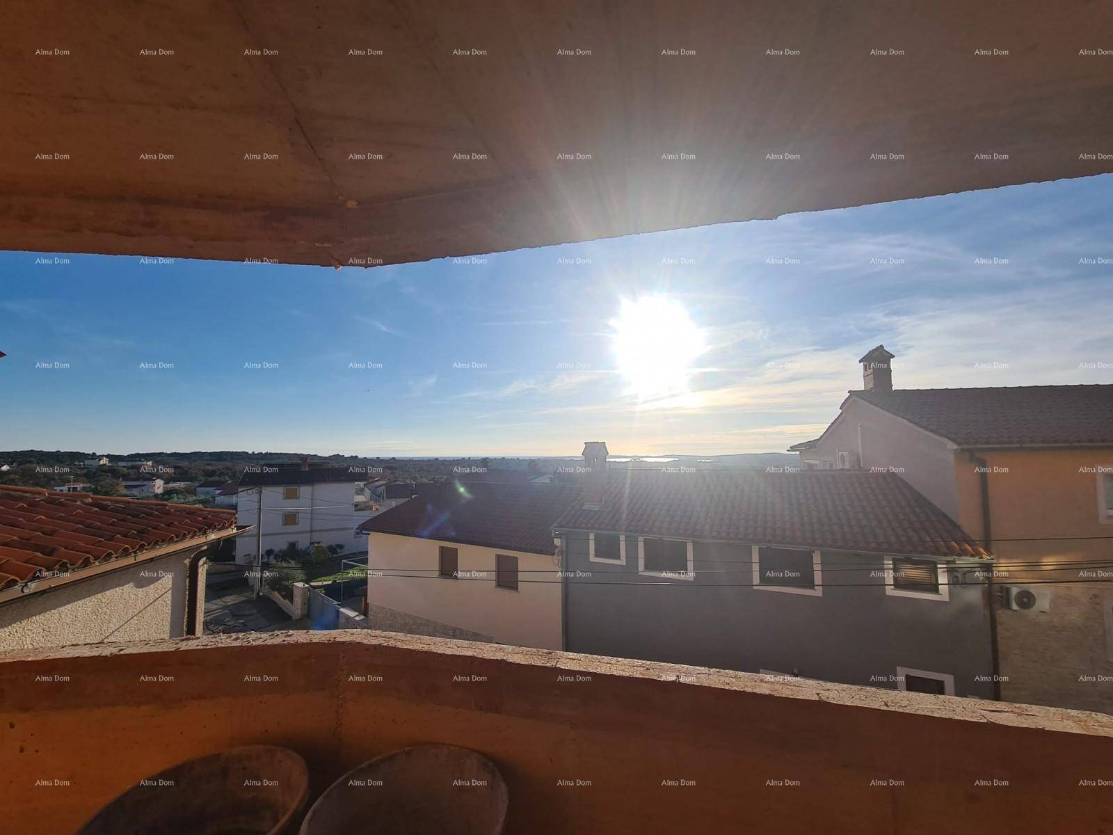 Sonniger Ausblick von einem Balkon auf die umliegende Wohngegend und das Meer in der Ferne.