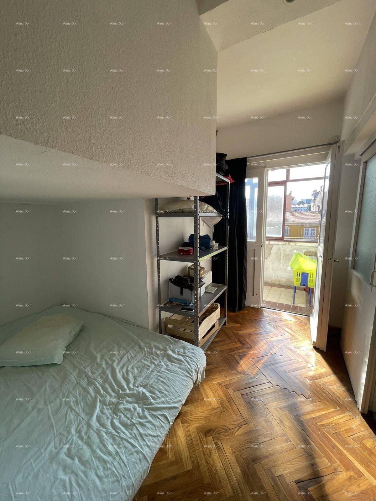 Schlafzimmer mit Holzboden, Bett und Zugang zu einem kleinen Balkon, hell und funktional.