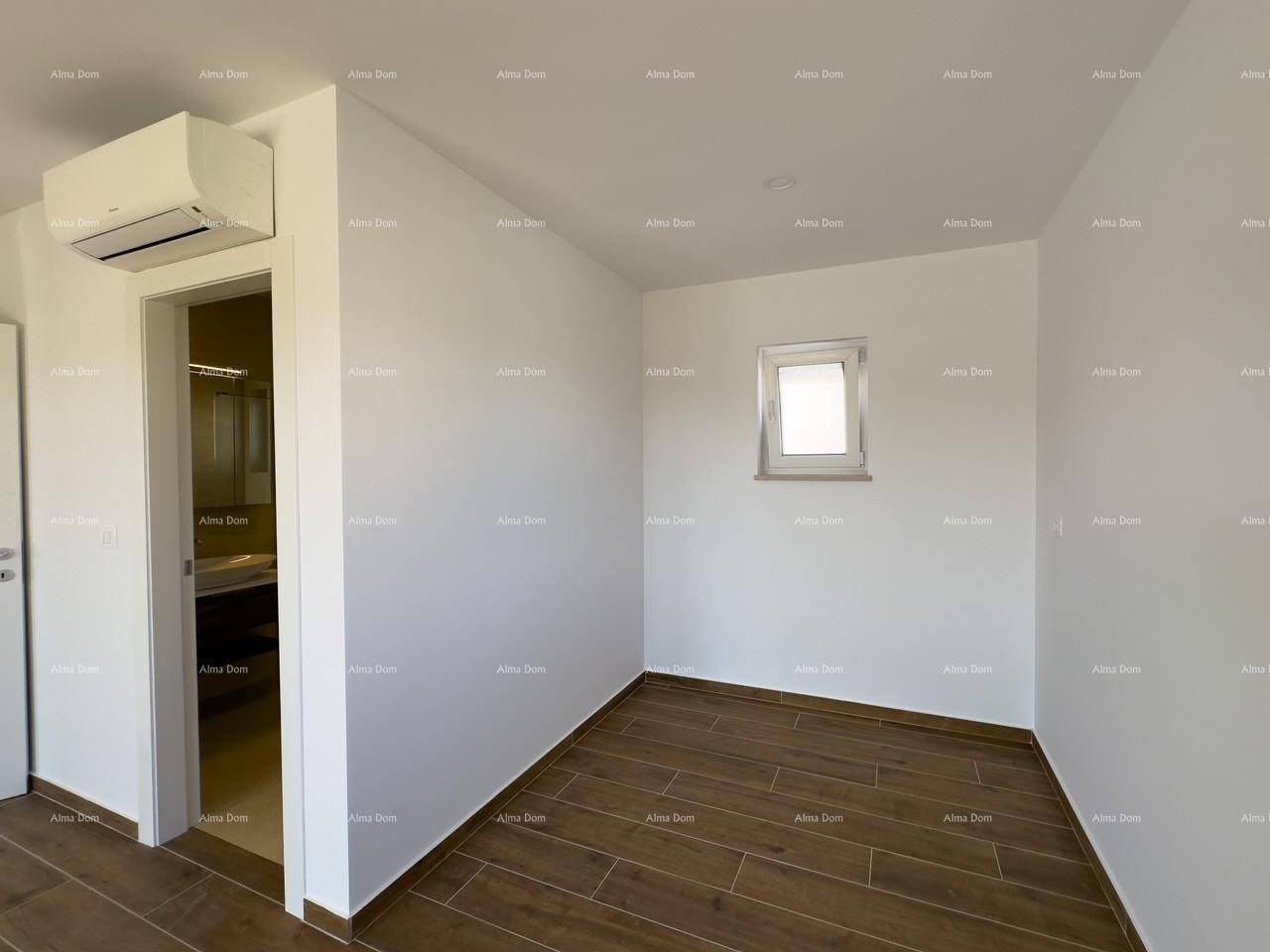 Helles Schlafzimmer mit Holzfliesenboden, Klimaanlage und direktem Zugang zum Badezimmer.