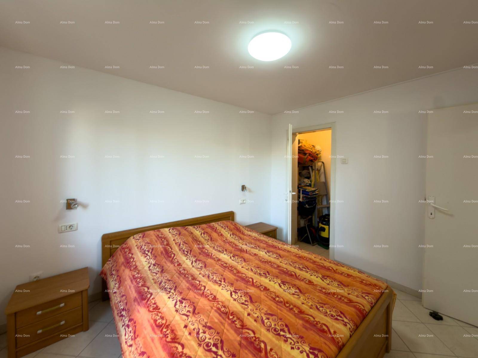 Schlafzimmer mit Doppelbett und Nachttischen, bietet Zugang zu einem praktischen Abstellraum.