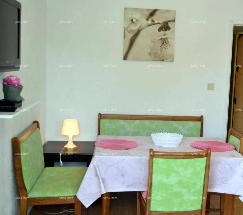 Gemütlicher Essbereich mit Holztisch und grünen Stühlen, dekoriert mit einem Bild.