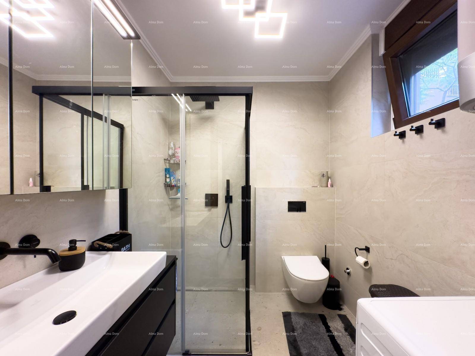 Helles Badezimmer mit moderner Dusche, Wand-WC und Waschmaschine unter dem Fenster.
