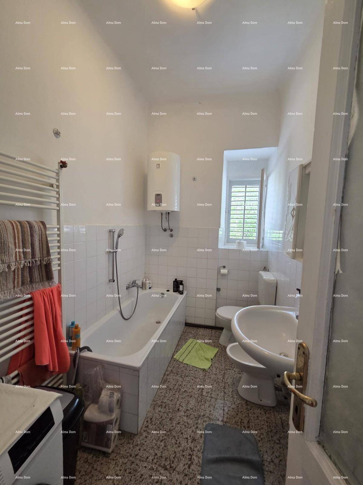 Badezimmer mit Badewanne, WC, Waschbecken und Fenster für natürliche Belüftung und Tageslicht.