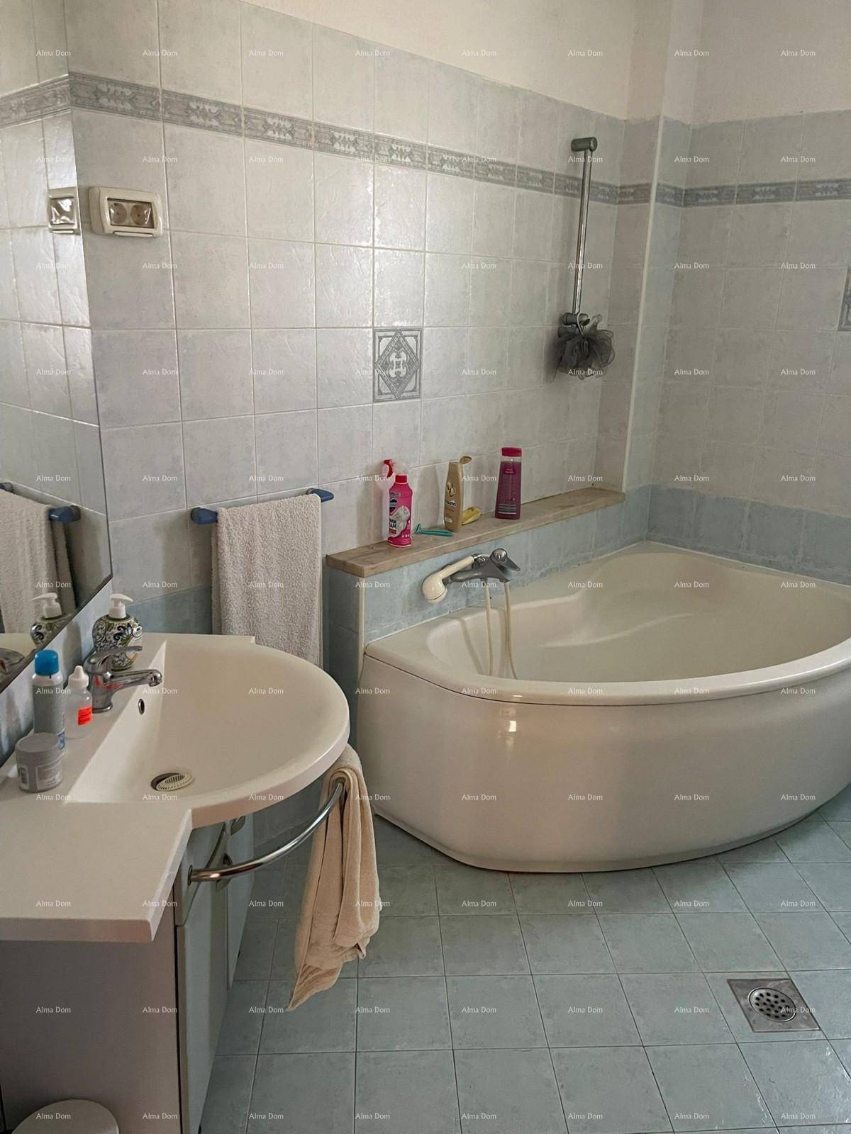 Helles Badezimmer mit Eckbadewanne, Fliesenboden und einem einzelnen Waschbecken.