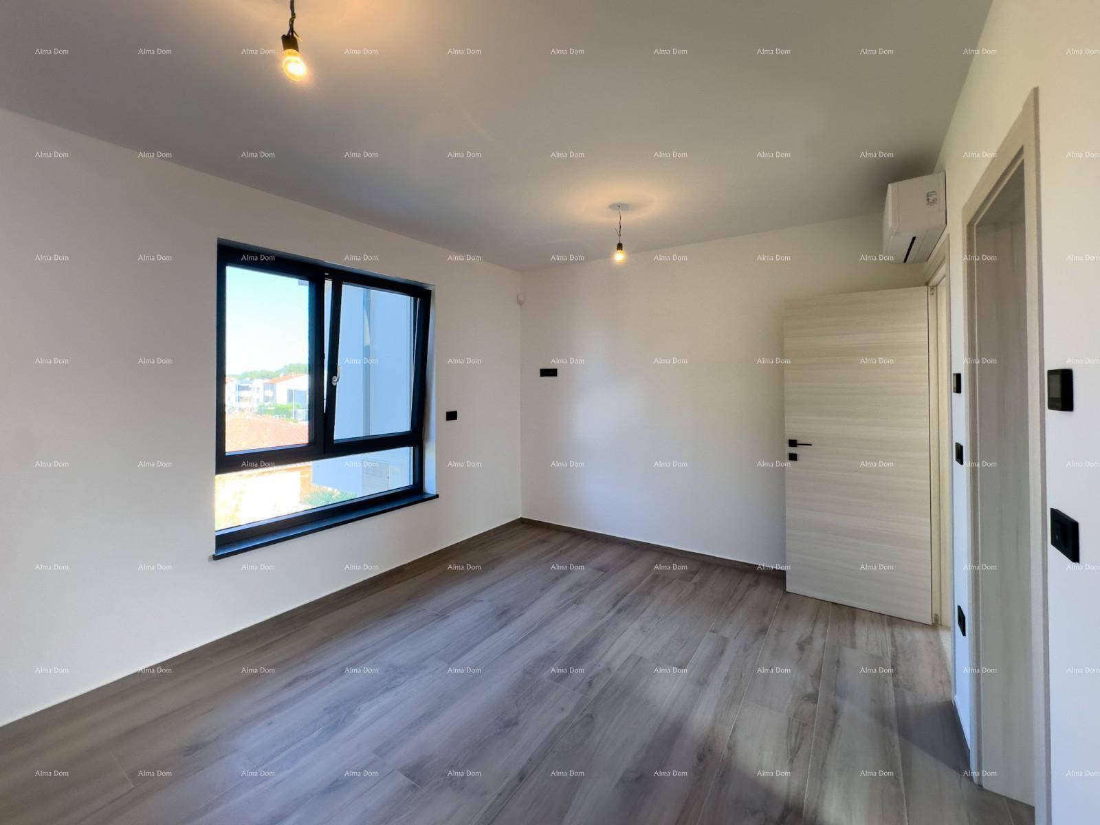 Leeres, helles Zimmer mit Laminatboden, großem Fenster und installierter Klimaanlage.