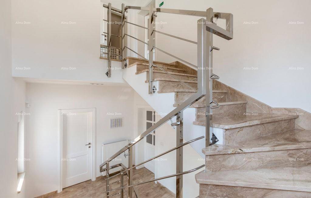 Elegante Marmortreppe mit modernem Edelstahlgeländer in einem hellen Treppenhaus.