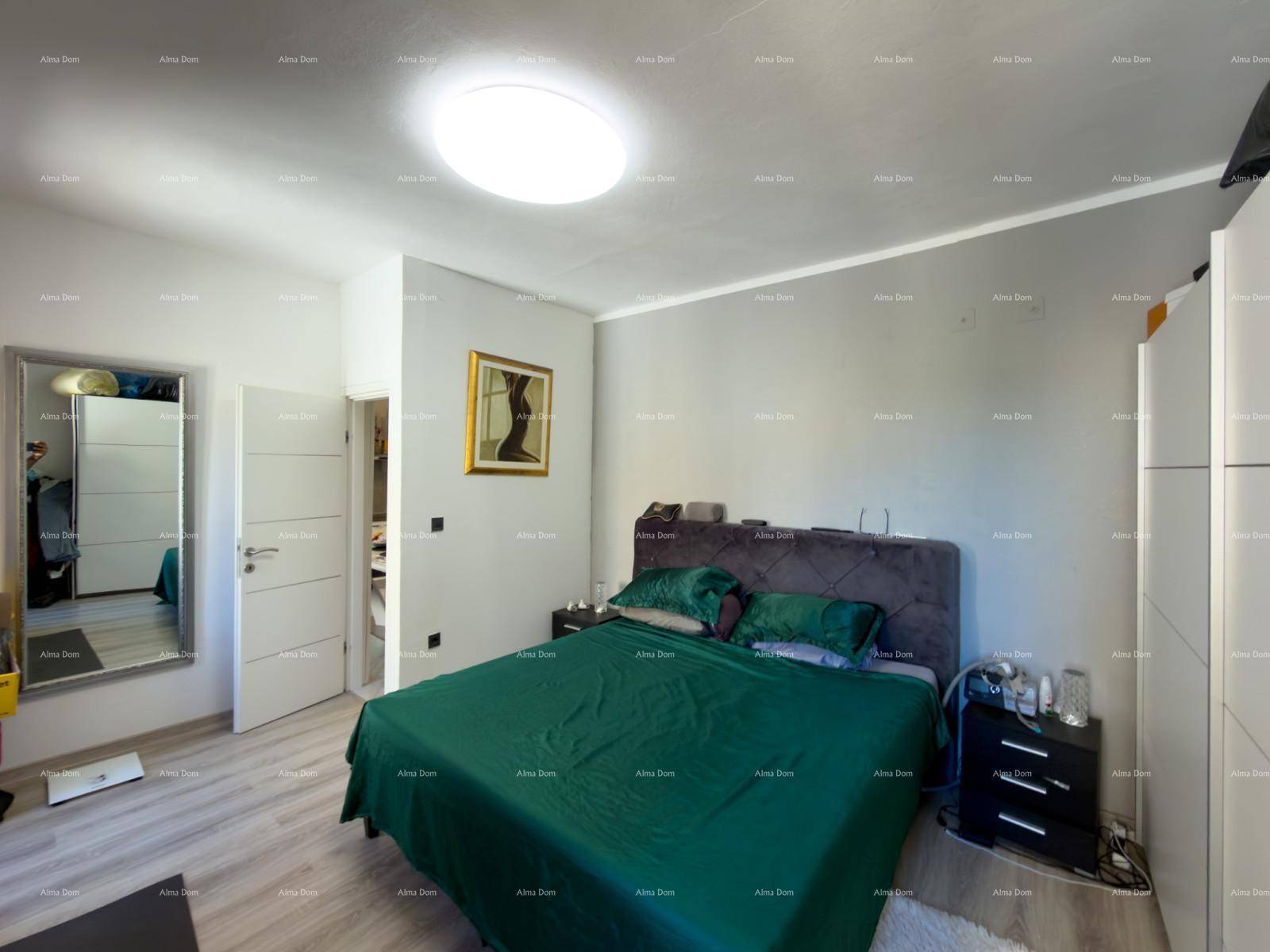Schlafzimmer mit Doppelbett, Kleiderschrank und Zugang zu einem weiteren Raum.
