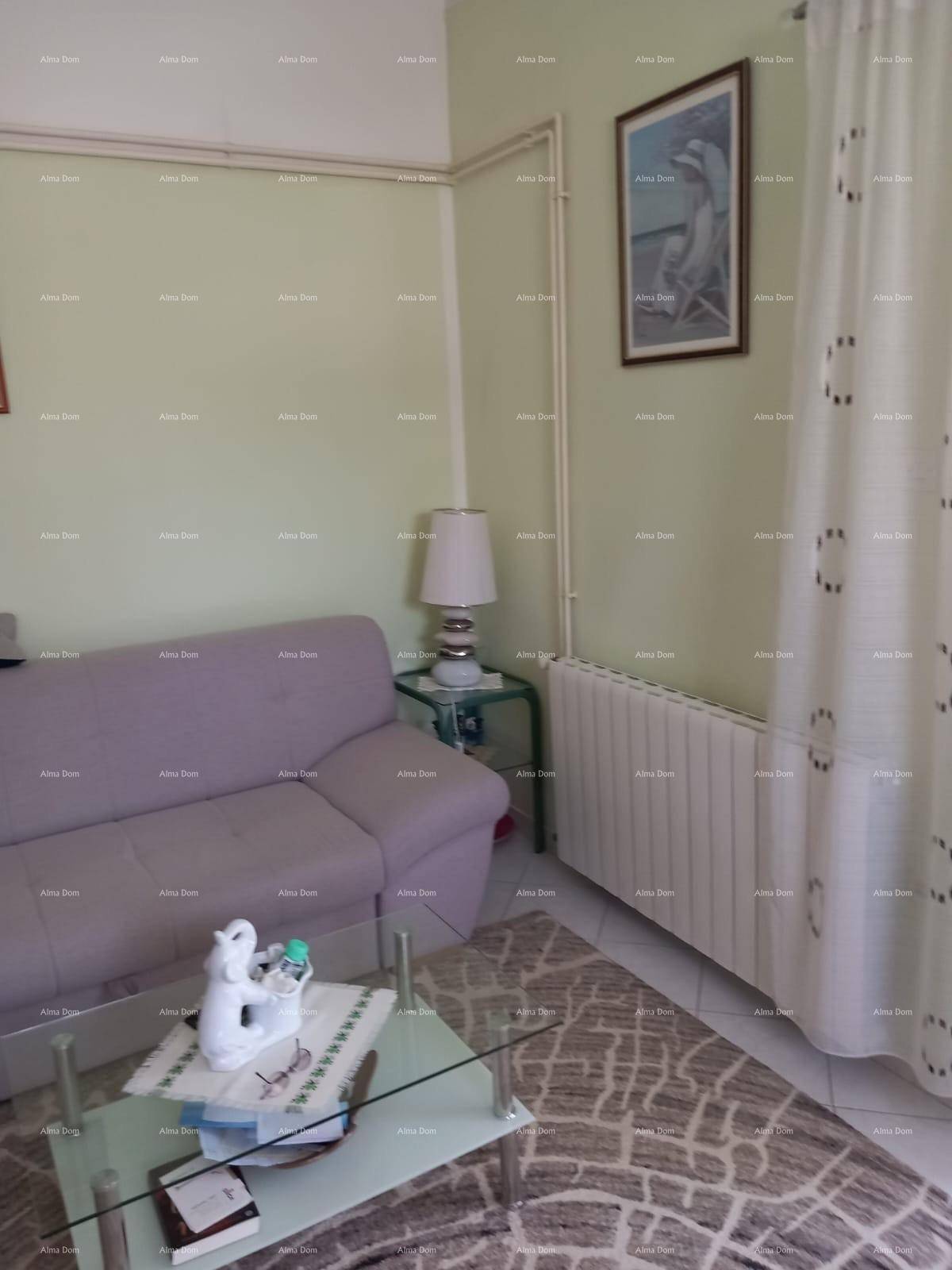 Gemütliches Wohnzimmer mit beiger Eckcouch, Couchtisch aus Glas und hellgrünen Wänden.