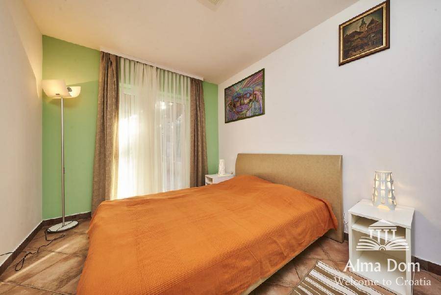 Schlafzimmer mit Doppelbett, Stehlampe und Zugang zu einem Balkon oder Terrasse.