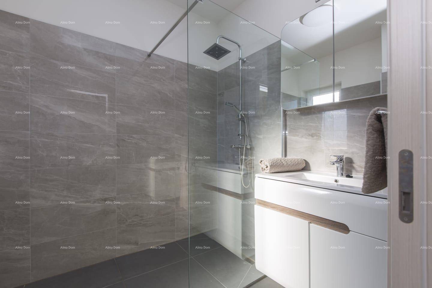 Modernes Badezimmer mit großer begehbarer Dusche, grauen Fliesen und elegantem Waschtisch.